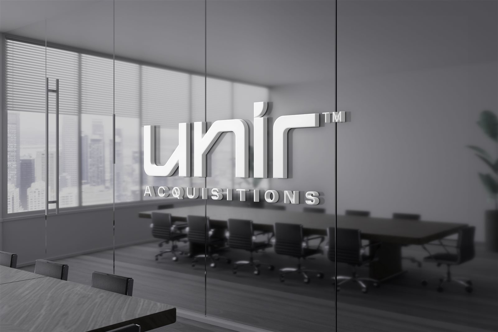 Marca UNIR ACQUISITIONS aplicada em relevo na parede de vidro de uma sala de reuniões corporativa
