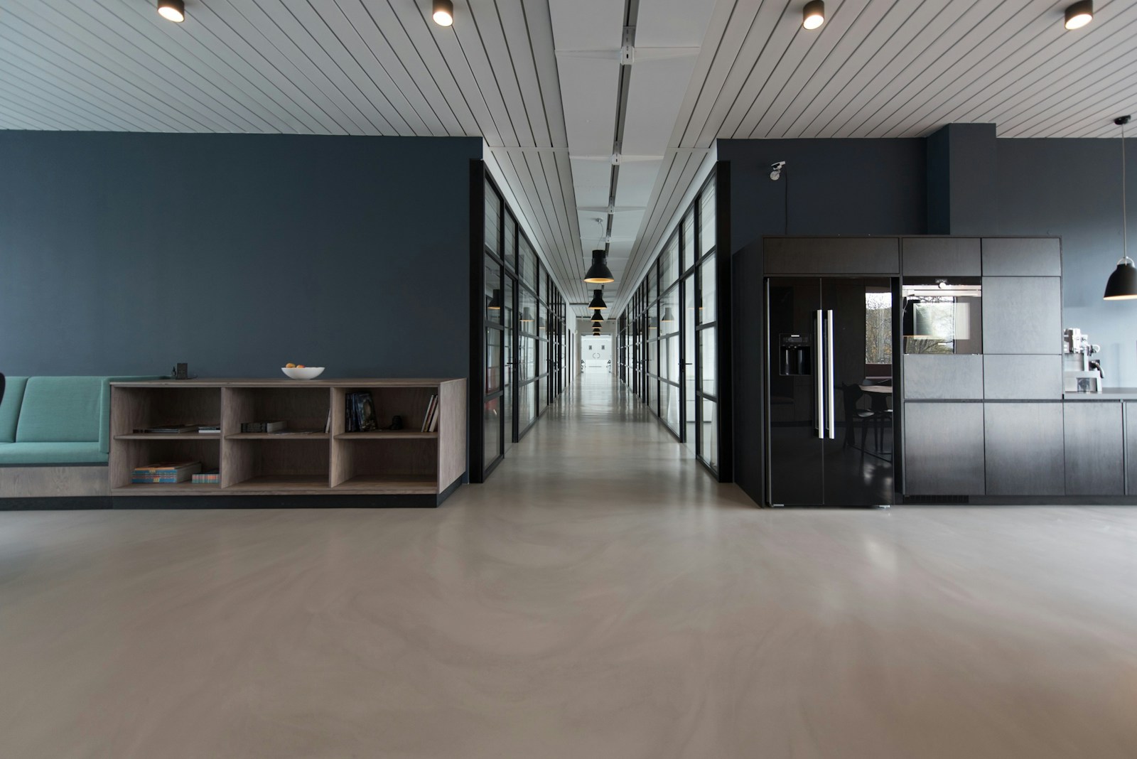 Ambiente corporativo organizado, com estações de trabalho e luz natural, em preto e branco